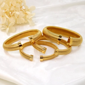 Vue détaillée de bracelets joncs en forme de C plaqués or 18K avec texture spirale