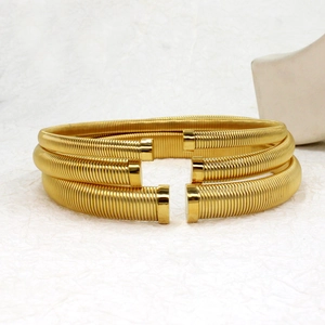 Detailed view of three stacked gold textured stainless steel open bangles with square ends
