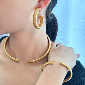 Golden Tubogas jewelry set including C-shape hoop earrings, open choker, and cuff bracelet