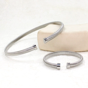 Detailed macro view of spiral silver choker and bracelet set on minimalist display