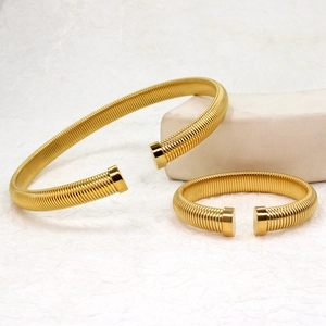 Detail of gold ribbed spiral jewelry set with an open collar necklace and bracelet