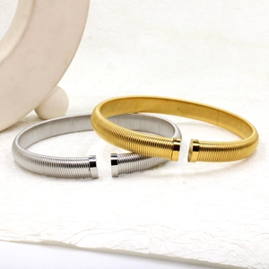Macro detail of gold and silver threaded stainless steel cuff bracelets with metal caps
