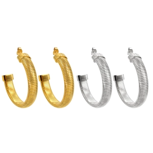 Macro detail of gold and silver Tubogas hoop earrings with spiral ribbed metal texture