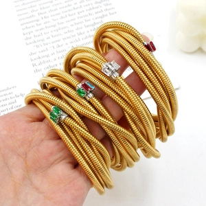 Golden multi-layer coiled snake bracelet with colorful zircon stones on woman's wrist
