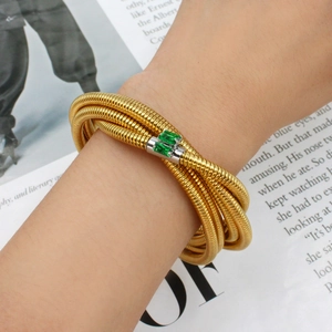 Stackable gold coiled bracelet with emerald-cut green zircon stones in vintage style