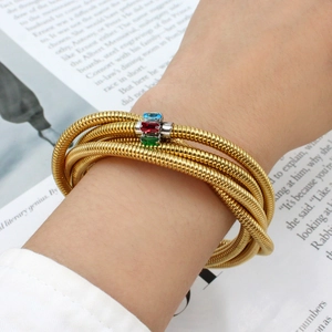Detailed shot of multi-layer gold snake chain bracelet with three-color zircon stones