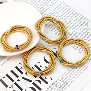 Stackable gold coiled wire bracelets featuring colorful rectangular zircon inlays for women