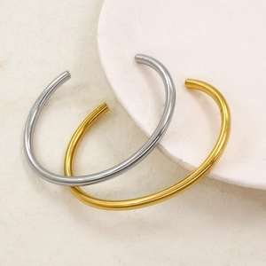Minimalist open bangle bracelet in polished gold and silver finish, sleek round metal design
