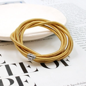 Detail of 18K gold multilayer snake chain bracelet with zircon inlaid clasp on a dish