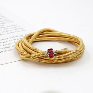 Detailed macro view of multilayer 18K gold snake chain bracelet with red zircon accents