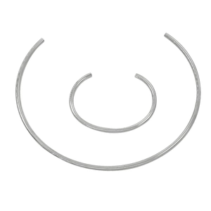Close-up of polished silver collar necklace and matching cuff bracelet set in C-shape