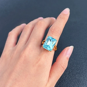 Detailansicht eines rechteckigen blauen Zirkonia-Rings mit Goldband im Vintage-Stil