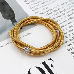 Close-up of golden multi-layer snake chain bracelet with silver zircon-set clasp