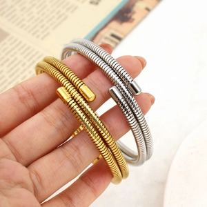 Close-up of gold and silver spring coil bracelets with spiral texture and polished caps