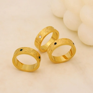 Dettaglio di anelli placcati in oro 18K con motivi a rilievo e pietre di zircone miste