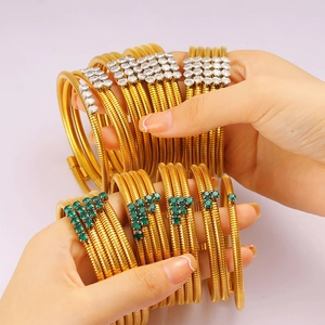 Detail of gold multi-layer wrap bracelets with green stones and clear zircon accents
