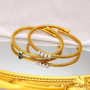 Detail of 18K gold-plated snake texture bracelets with green and white zircon stones