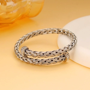 Detail eines silbernen geflochtenen Armbands mit Zirkon-Akzenten und gedrehtem Design