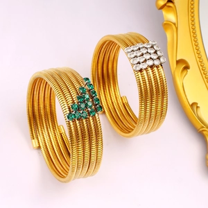 Detail of multi-layer gold snake wrap bracelets with green and white zircon crystals
