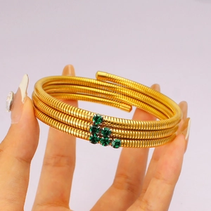Detail of gold multi-layer Tubogas wrap bracelet with green zircon rhinestone accents