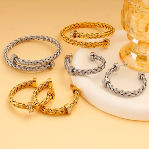 Detailaufnahme von gewebtem Gold- und Silberschmuckset mit Zirkonia auf einem Sockel