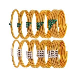Gold multi-layer coil bracelet set with green and clear zircon stones on white background