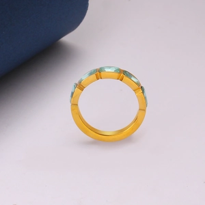 Primo piano dell'anello eternity in acciaio dorato 18K con pietre preziose azzurre
