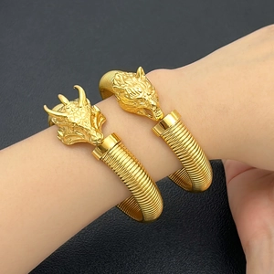 Brazaletes abiertos de acero dorado con cabezas de leopardo y dragón y diseño roscado