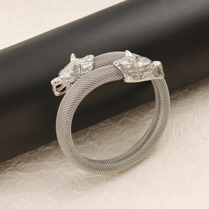 Detalle de cabezas de lobo plateadas en un brazalete de malla de acero inoxidable