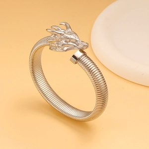Detalle del brazalete de cabeza de dragón plateado con texturas metálicas y grabados