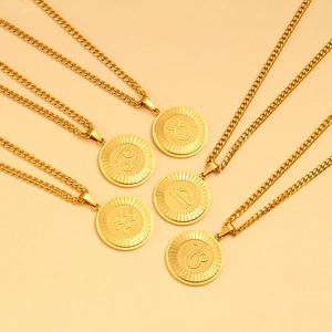 Macro shot of gold zodiac pendant necklaces with Cuban chain and celestial symbols