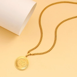 Close-up of golden stainless steel Virgo zodiac pendant with radial textured details