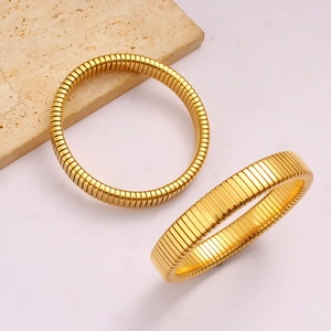 Macro shot of gold-plated titanium steel bracelet with detailed snake-bone spiral texture