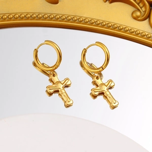 Detalle macro de pendientes de aro en acero chapado en oro de 18K con colgante cruz