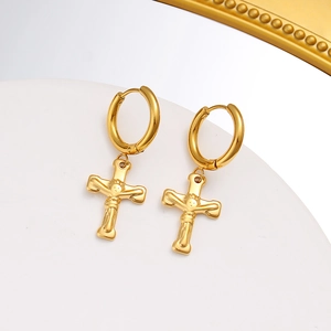 Detalle de los pendientes de aro en acero chapado en oro de 18K con colgantes de cruz
