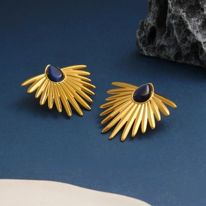 Macro detail of retro fan-shaped golden earrings with teardrop blue cat's eye stones