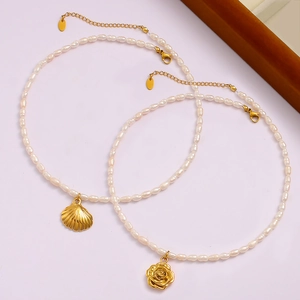 Detail von 18K Gold Rosen- und Muschelanhängern an Perlenketten mit Verlängerungsketten