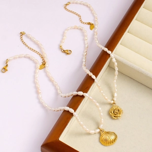 Französische Perlenkette mit 18K Gold Rose und Muschel Anhänger auf einer Schmuckbox