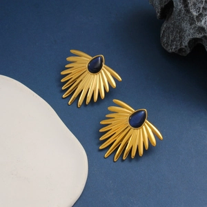 Detailed close-up of vintage golden fan-shaped earrings with blue teardrop stone