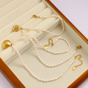 Detail von 18K Gold Rosen- und Muschelanhängern an einer edlen Perlenhalskette