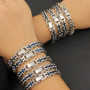 Gros bracelet gourmette hip hop en acier inoxydable bicolore porté au poignet par un modèle
