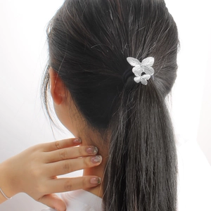 Élastique à cheveux avec double papillon en métal argenté sur un lien élastique noir