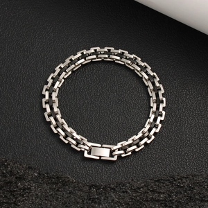 Détail du bracelet gourmette en acier inoxydable avec inserts noirs et fermoir robuste