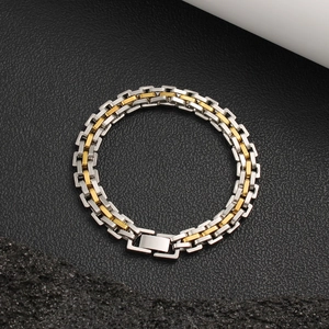 Détail macro du bracelet à maillons industriels bicolore en acier inoxydable argent et or