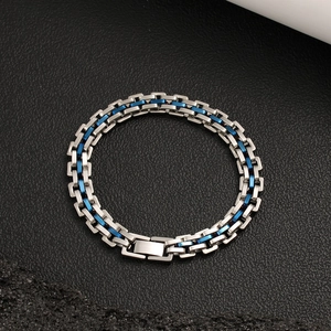 Détail d'un bracelet en acier inoxydable avec maillons bleus sur fond noir texturé