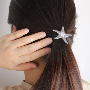 Élastique à cheveux avec étoile de mer argentée et perles sur les cheveux