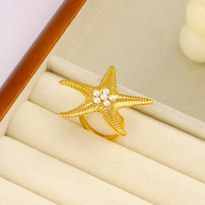 Dettaglio macro dell'anello a stella marina dorata con perle in scatola per gioielli