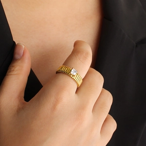 Detail of 18K gold-plated striped ring with square zircon on model in business attire