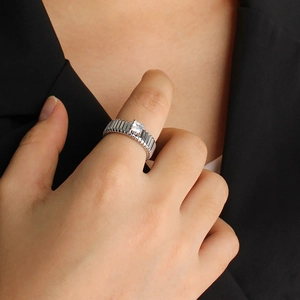 Detail of silver vertical striped ring with square cubic zirconia stone in a 4-prong setting