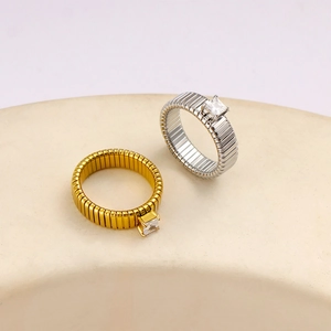 Minimalist square zircon ring set with gold and silver link bands on a ceramic base